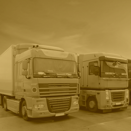 Photo of a lorries in a line that is greyscale with a yellow filter.