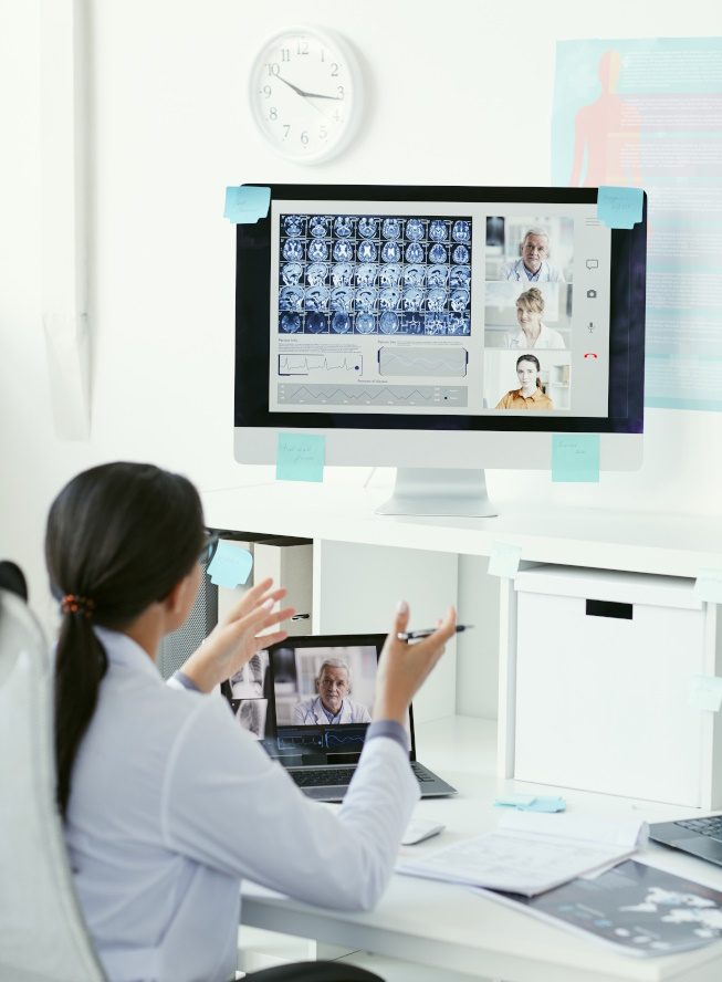 Photo of woman talking to other healthcare professionals, digitally.