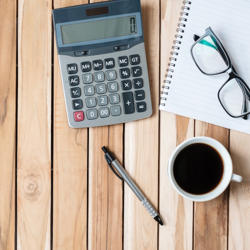 Calculator, book, glasses coffee and pen, to represent finance industry.
