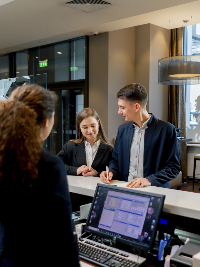 Photo of people checking into a hotel. 