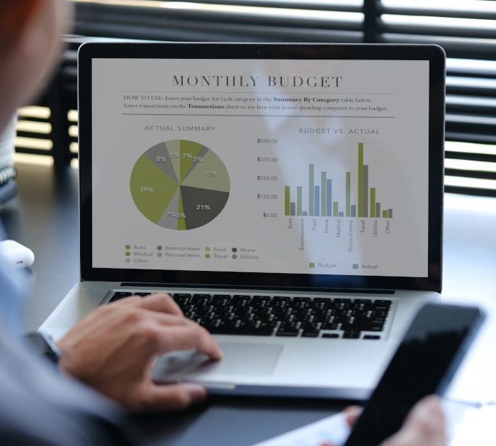 Photo of laptop with monthly budget, charts and graphs on the screen to represent financial reporting software.